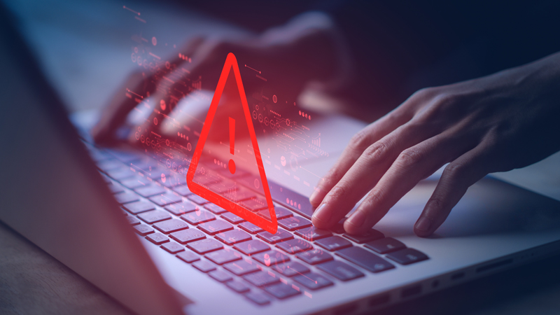 mani su tastiera pc e simbolo di pericolo